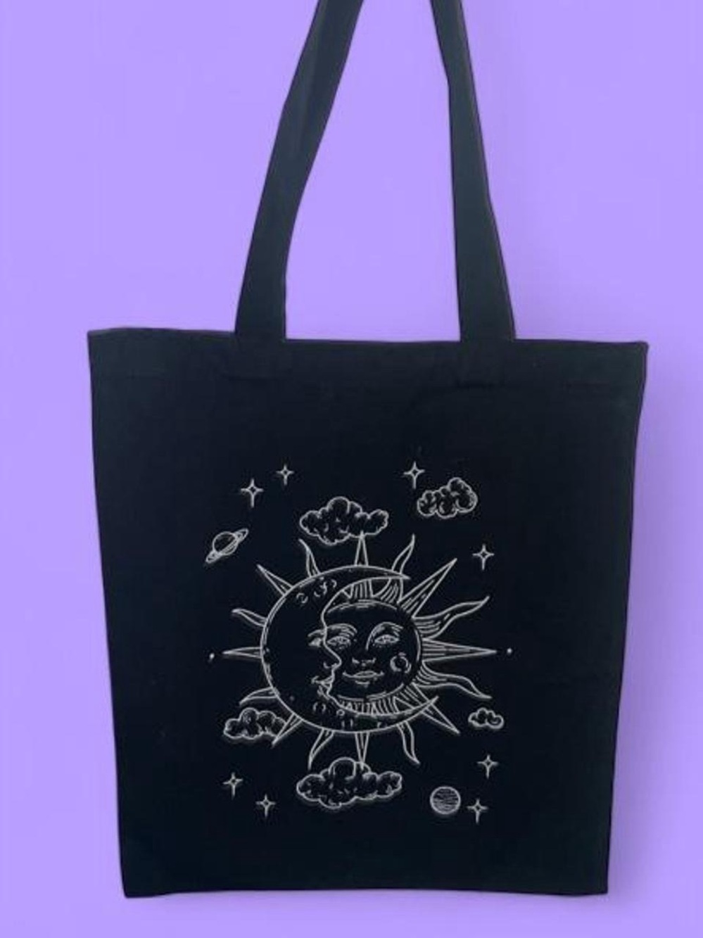 Black celestial tote bag with sun and moon graphic